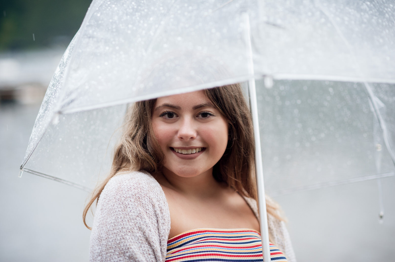 senior in Athens Ohio with clear umbrella for rainy day photographs