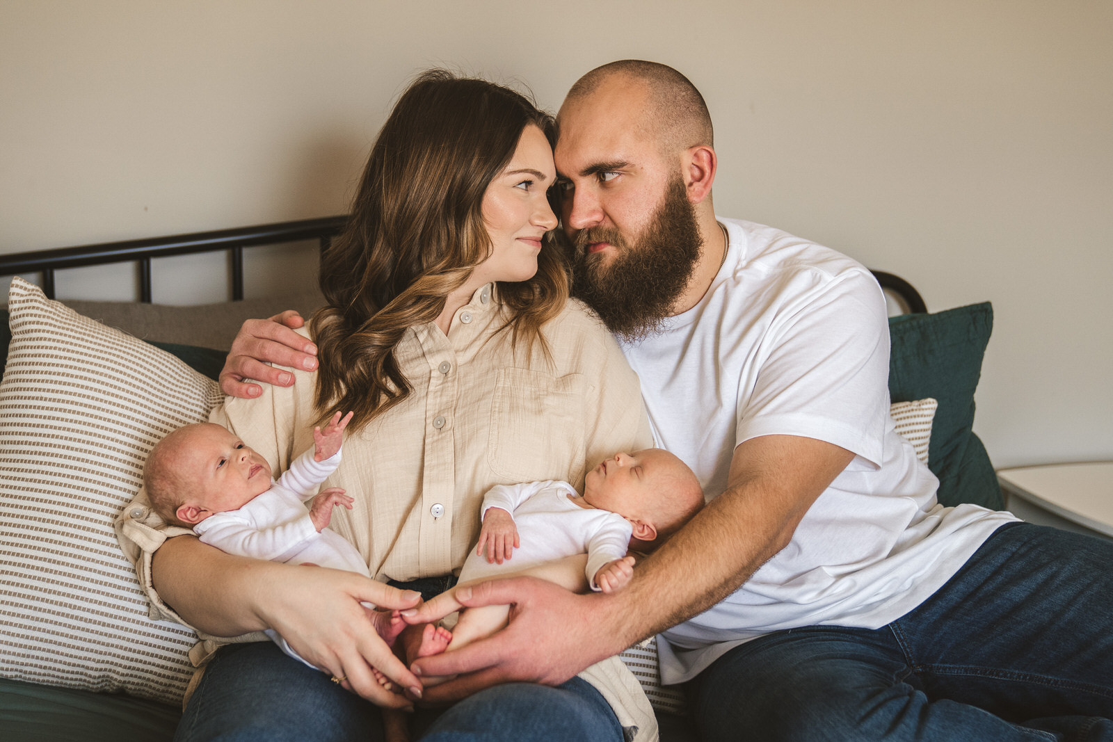 newborn twins photos with mom and dad sitting on bed together