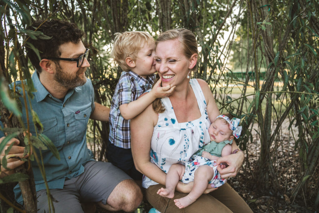 outdoor newborn photography session in green bushes