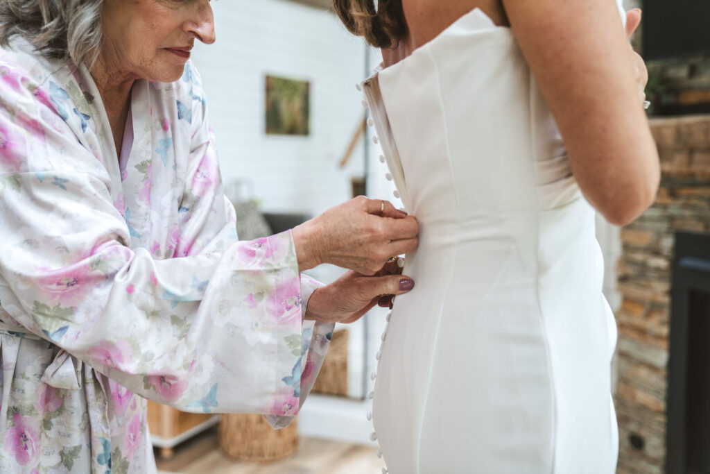 mother zipping up wedding dress at Hideaway on the hocking